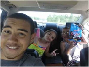 Kids in backseat eating snacks.