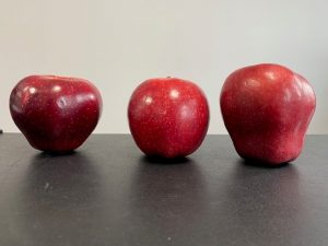 Three red apples lined up on a table, used to illustrate funding a Health Saving Account